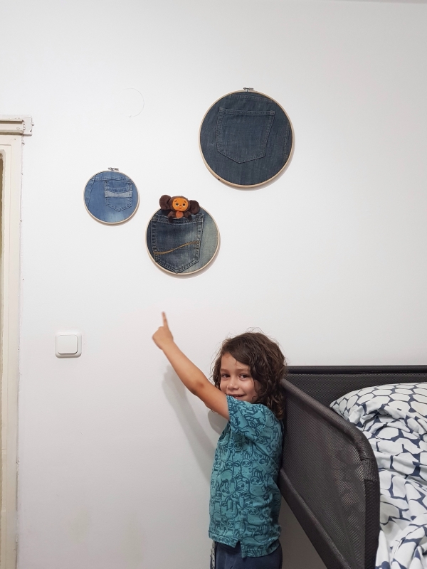 Embroidery gings with reused jeans hanging on a kids room wall